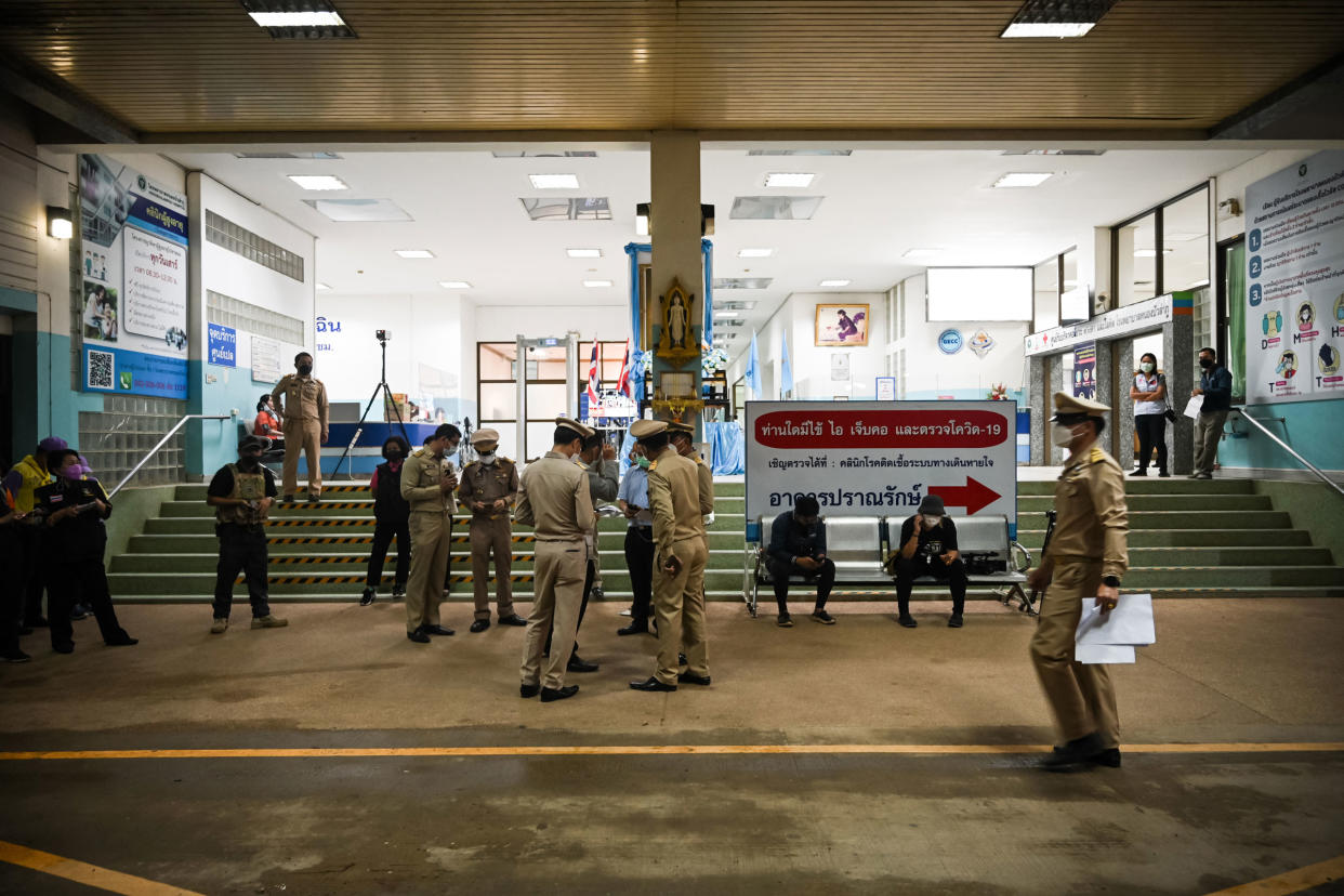 Police officers stand outside a hospital where the injured are being treated on Oct. 6, 2022 after a shooting in Uthai Sawan subdistrict, Nong Bua Lamphu, Thailand.