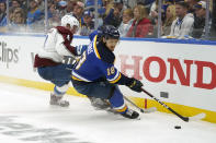 St. Louis Blues' Robert Thomas (18) and Colorado Avalanche's Cale Makar (8) chase after a loose puck along the boards during the second period in Game 3 of an NHL hockey Stanley Cup second-round playoff series Saturday, May 21, 2022, in St. Louis. (AP Photo/Jeff Roberson)