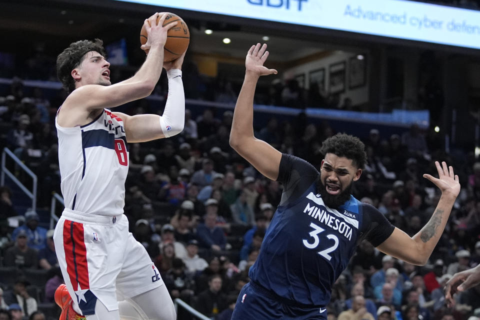 Washington Wizards forward Deni Avdija (8) shoots over Minnesota Timberwolves center Karl-Anthony Towns (32) during the first half of an NBA basketball game Wednesday, Jan. 24, 2024, in Washington. (AP Photo/Mark Schiefelbein)