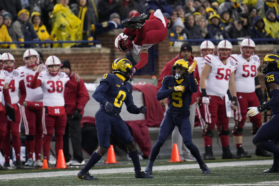 Nebraska wide receiver Alante Brown (4) is upended by Michigan defensive back Mike Sainristil (0) as DJ Turner (5) looks on in the first half of an NCAA college football game in Ann Arbor, Mich., Saturday, Nov. 12, 2022. (AP Photo/Paul Sancya)