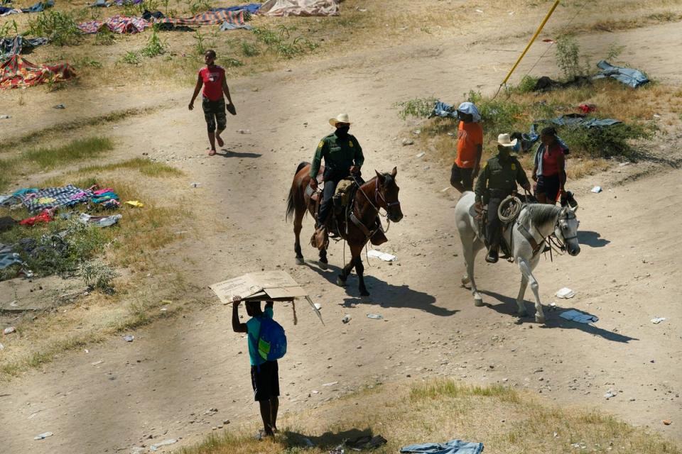 Border Patrol agents pass Haitian migrants at a makeshift camp, Sept. 17, 2021, in Del Rio, Texas (AP)