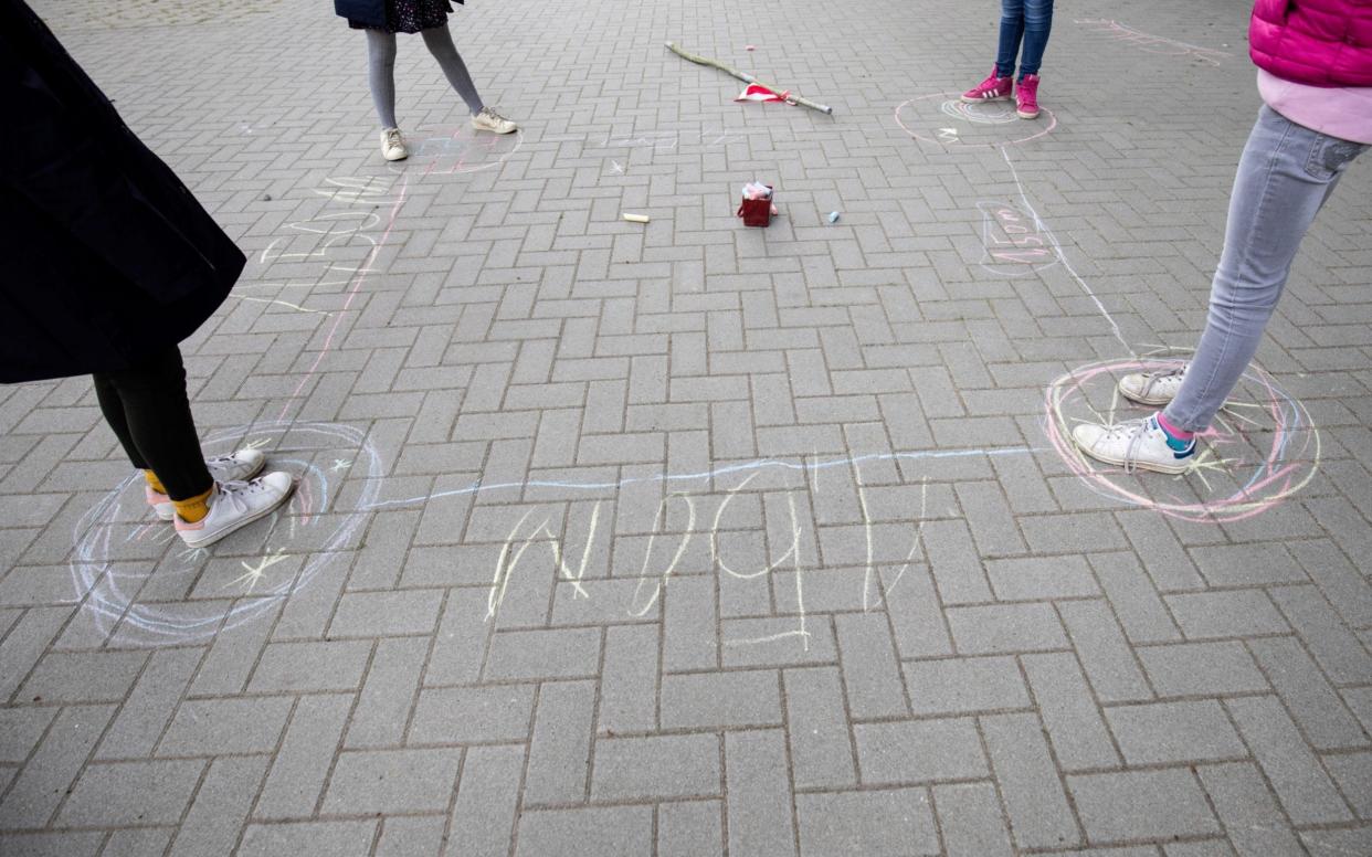 Children in Germany observe distancing rules in the playground - similar measures are set to be introduced in Scotland - Christian Charisius/DPA