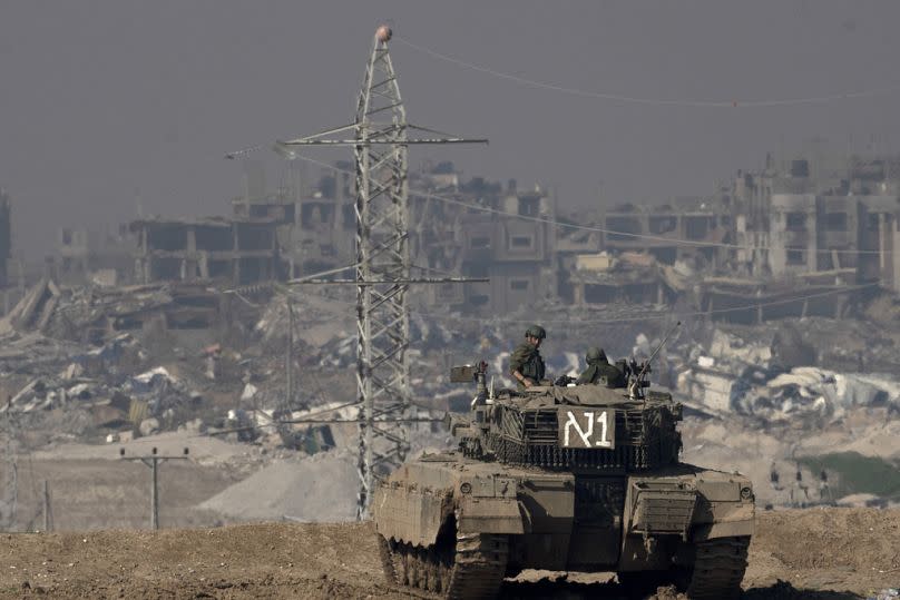 Israeli soldiers overlook the Gaza Strip from a tank, as seen from southern Israel