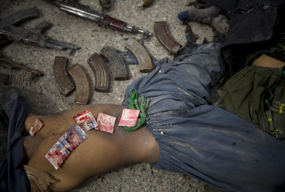 FILE - In this Wednesday, March 12, 2014 file photo made by Associated Press photographer Anja Niedringhaus, Pakistani bank notes covered in blood are displayed on the body of a dead suicide bomber after police found them in his pocket after an attack on the former Afghan intelligence headquarters, in the center of Kandahar, Afghanistan. Niedringhaus, 48, an internationally acclaimed German photographer, was killed and AP reporter Kathy Gannon was wounded on Friday, April 4, 2014 when an Afghan policeman opened fire while they were sitting in their car in eastern Afghanistan. (AP Photo/Anja Niedringhaus, File)