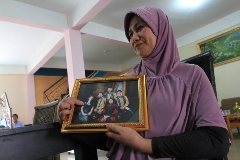 The mother of an Indonesian flight attendant who was travelling on AirAsia Flight QZ8501, points at her daughter on family photograph in Palembang, South Sumatra, on December 28, 2014