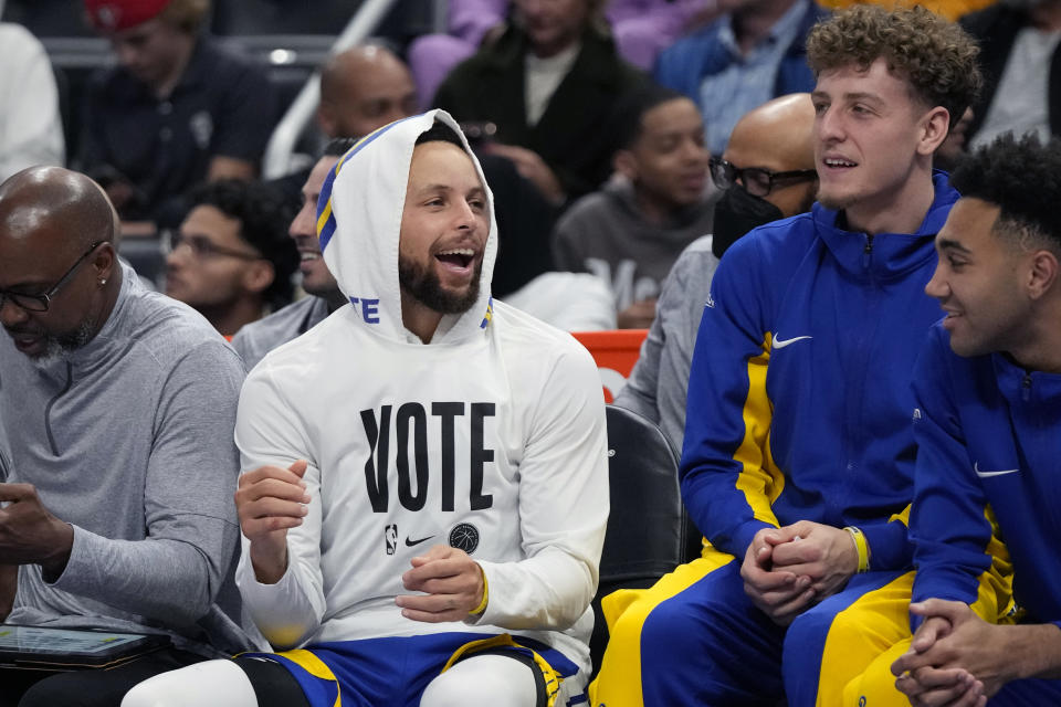 Golden State Warriors guard Stephen Curry laughs with teammates during the first half of an NBA basketball game against the Detroit Pistons, Monday, Nov. 6, 2023, in Detroit. (AP Photo/Carlos Osorio)