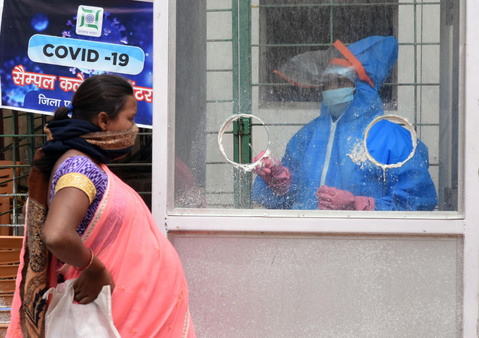 RANCHI, INDIA - APRIL 26: A medical worker in a PPE suit takes a swab sample while conducting a COVID-19 test of a pregnant woman at a Corona testing centre, during a nationwide lockdown in the wake of coronavirus pandemic, on April 26, 2020 in Ranchi, India. (Photo by Diwakar Prasad/Hindustan Times via Getty Images)