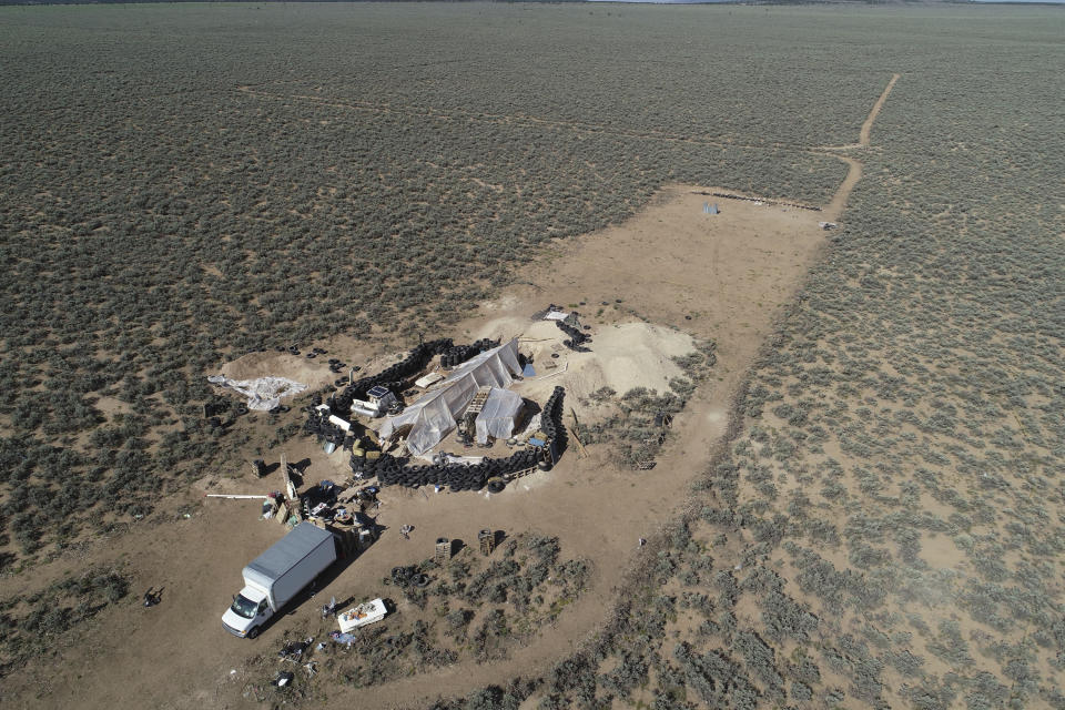 FILE - In this Friday, Aug. 10, 2018 file photo aerial view of a makeshift compound is seen in the desert area of Amalia, N.M. New Mexico forensic investigators announced Thursday, Aug. 16, that a highly decomposed body found at a desert compound in New Mexico has been identified as a missing Georgia boy whose father is accused of kidnapping him and performing purification rituals on the severely disabled child. The New Mexico Office of the Medical Investigator said Thursday that the remains were those of Abdul-ghani Wahhaj. (AP Photo/Brian Skoloff, File)