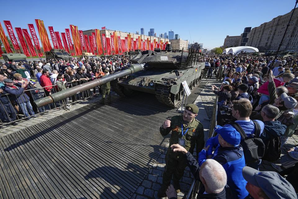 Visitors look at and take photos of a a German made Leopard 2A6 tank, hit and captured by Russian troops during the fighting in Ukraine which is seen on display in Moscow, on Wednesday, May 1, 2024. An exhibition of military equipment captured from Kyiv forces during the fighting in Ukraine has opened in the Russian capital. (AP Photo/Alexander Zemlianichenko)