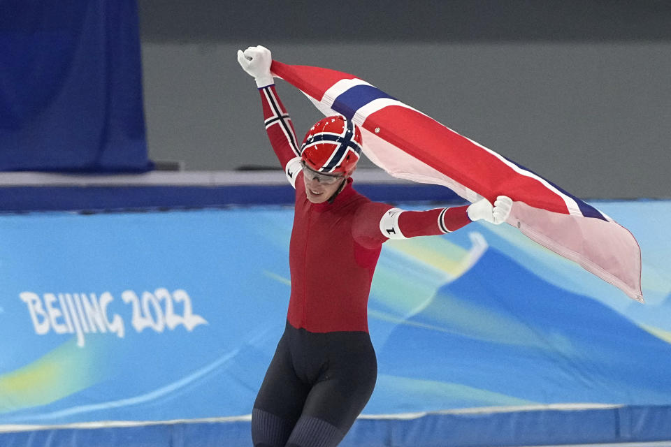 Hallgeir Engebraaten of Team Norway waves his country's flag as he skates on the ice after they won the gold medal in the speedskating men's team pursuit finals at the 2022 Winter Olympics, Tuesday, Feb. 15, 2022, in Beijing. (AP Photo/Ashley Landis)