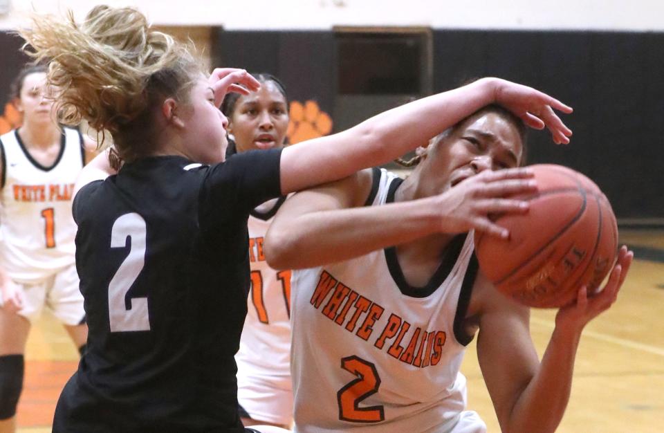 White Plains' Aliya McIver tries to get to the hoop under New Rochelle's Rylie Rosenberg during a Section 1 Class AA quarterfinal at Mamaroneck Feb. 24, 2023. White Plains won 65-42.