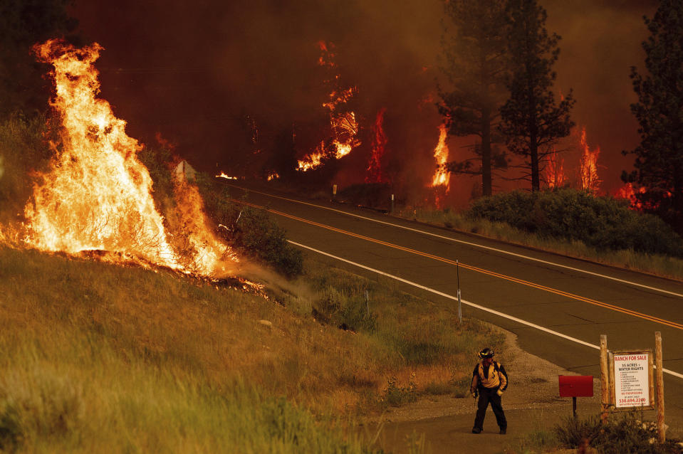 A firefighter walks towards a home in the Markleeville community of Alpine County, California, on July 17.