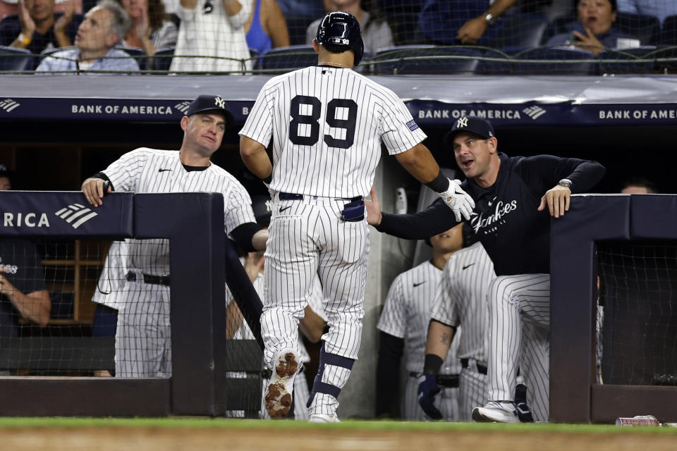 New York Yankees' Jasson Dominguez (89) is congratulated by manager Aaron Boone, right, after hitting a home run against the Detroit Tigers during the fourth inning of a baseball game Wednesday, Sept. 6, 2023, in New York. The Yankees won 4-3. (AP Photo/Adam Hunger)