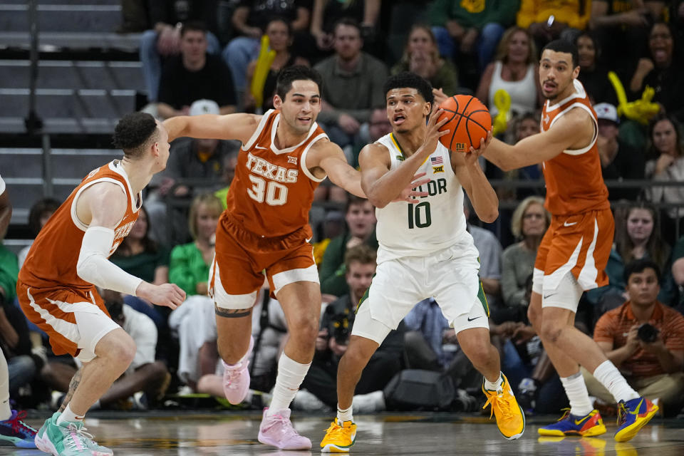 Baylor's RayJ Dennis (10) collects a rebound against Texas's Chendall Weaver, left, Brock Cunningham (30) and Dylan Disu (1) during the first half of an NCAA college basketball game, Monday, March 4, 2024, in Waco, Texas. (AP Photo/Julio Cortez)