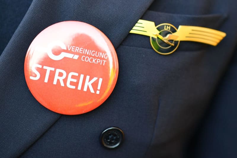 A Lufthansa pilot wears a button with the words "Strike" on his uniform at a rally organized by the German Airline Pilots' Association Vereinigung Cockpit (VC). Uwe Anspach/dpa