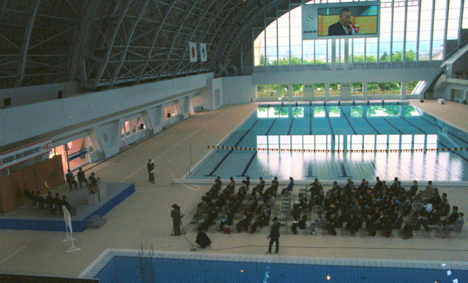 In this May 16, 1999 photo, an aquatics center is unveiled during a ceremony in Nagano, central Japan. The Aqua Wing Arena, which hosted the ice hockey events in the 1998 Winter Olympics, was converted into an aquatics center. In Nagano, a city with a population of just 387,000, five large structures were built for the 1998 Winter Games. They are in use, but many say the venues are too big and costly to maintain for the size of the town. (AP Photo/Kyodo News) JAPAN OUT.