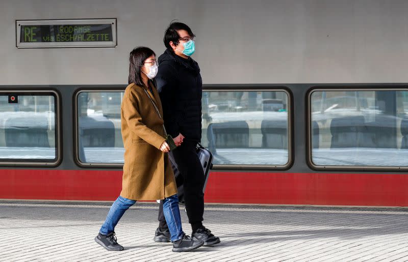 Tourists wearing masks walk on a platform at Luxembourg railway station