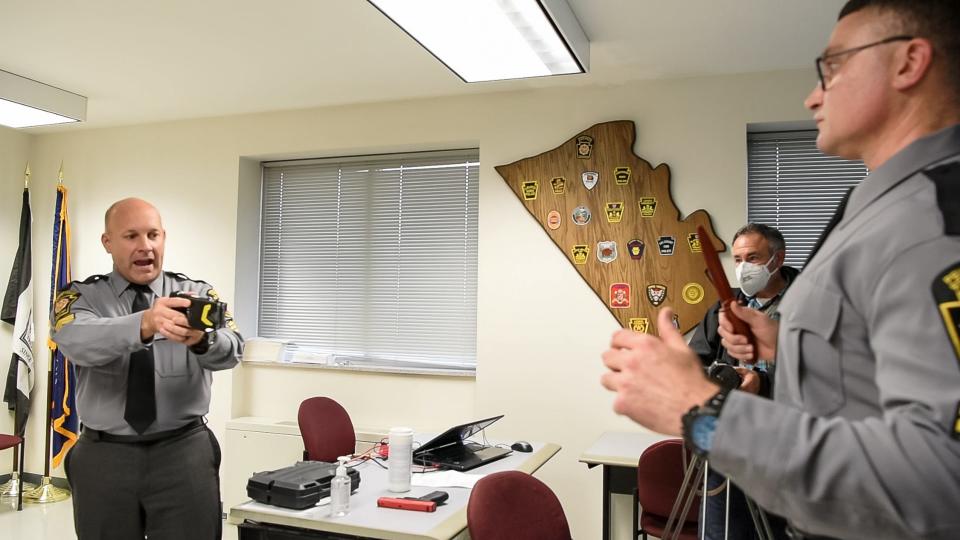 Pennsylvania State Police Sgt. Timothy Fetzer, left, and Cpl. Kevin Selverian, demonstrate the complexities of Taser use during a use-of-force presentation last year. When used properly, Tasers can help officers subdue threatening and unruly subjects without the need for deadly force or physical restraint maneuvers with less risk to suspects and officers.