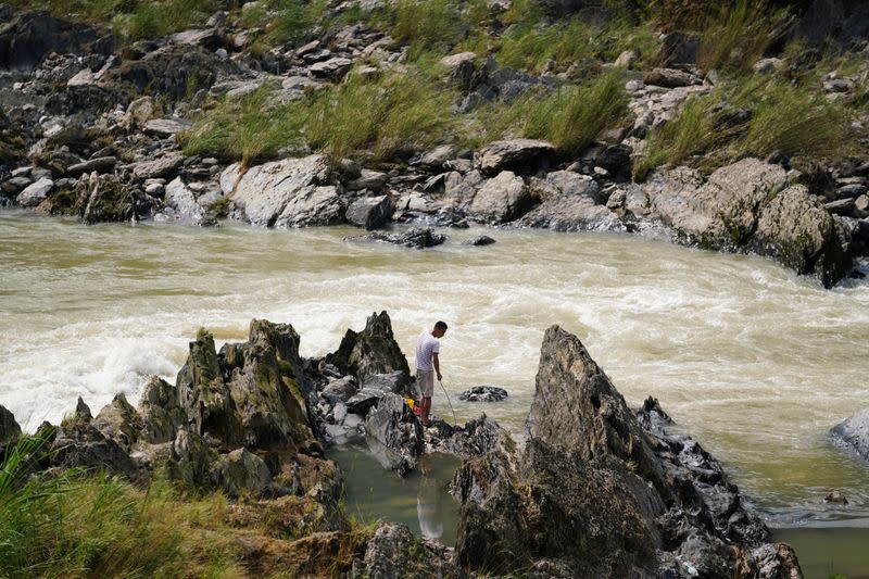 Man fishes at the downstream of the Qingshitan reservoir at Gantang river in Yangshuo