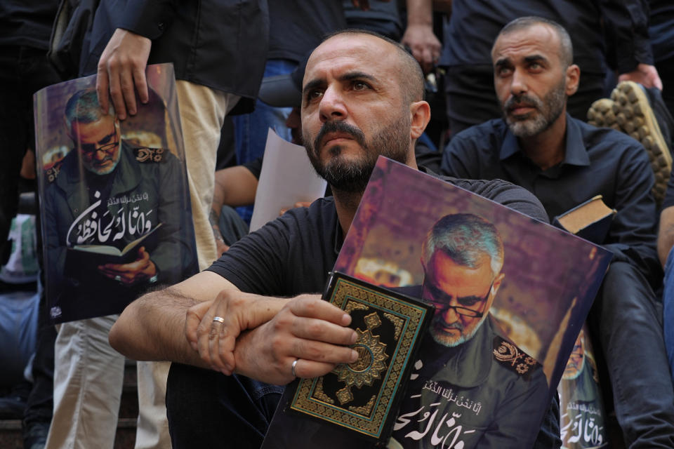 Hezbollah supporters hold the Quran and portraits of slain Iran's Quds force General Qassem Soleimani, during a rally after Friday prayers in the southern Beirut suburb of Dahiyeh, Lebanon, Friday, July 21, 2023. Muslim-majority nations expressed outrage Friday at the desecration of the Islamic holy book in Sweden. Following midday prayers, thousands took to the streets to show their anger, in some cases answering the call of religious and political leaders. (AP Photo/Bilal Hussein)