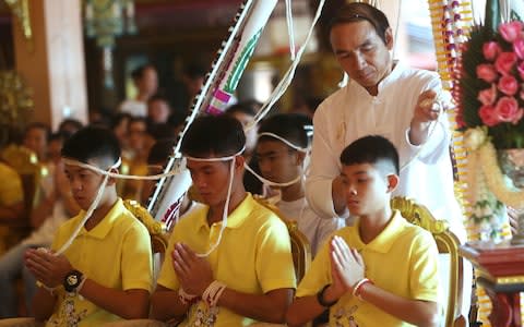 Members of the rescued football team take part in a religious ceremony - Credit: AP