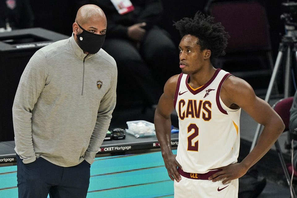 Cleveland Cavaliers coach J.B. Bickerstaff, left, talks with Collin Sexton during the second half of the team's NBA basketball game against the New York Knicks, Tuesday, Dec. 29, 2020, in Cleveland. The Knicks won 95-86. (AP Photo/Tony Dejak)