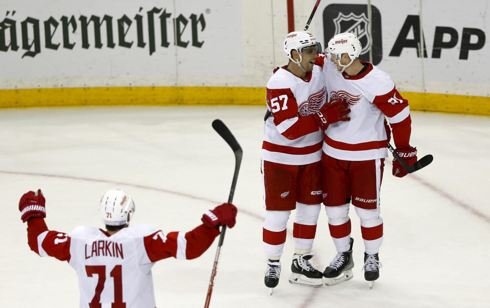 From left to right, Detroit Red Wings players Dylan Larkin, David Perron and Dominik Kubalik celebrate Kubalik's winning overtime goal during an NHL hockey game against the New York Rangers, Sunday, Nov. 6, 2022, in New York. (AP Photo/John Munson)