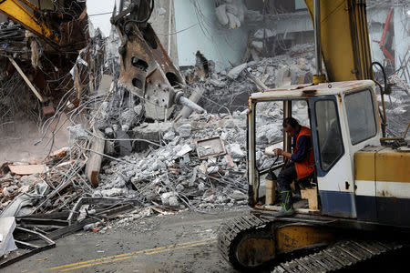 An excavator demolishes collapsed Marshal hotel after an earthquake hit Hualien, Taiwan February 9, 2018. REUTERS/Tyrone Siu