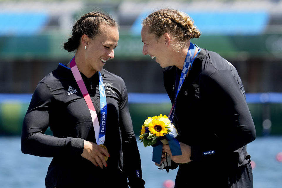 Lisa Carrington, left, and Caitlin Regal, of New Zealand, celebrate their gold medals after winning the women's kayak double 500m final at the 2020 Summer Olympics, Tuesday, Aug. 3, 2021, in Tokyo, Japan. (AP Photo/Lee Jin-man)