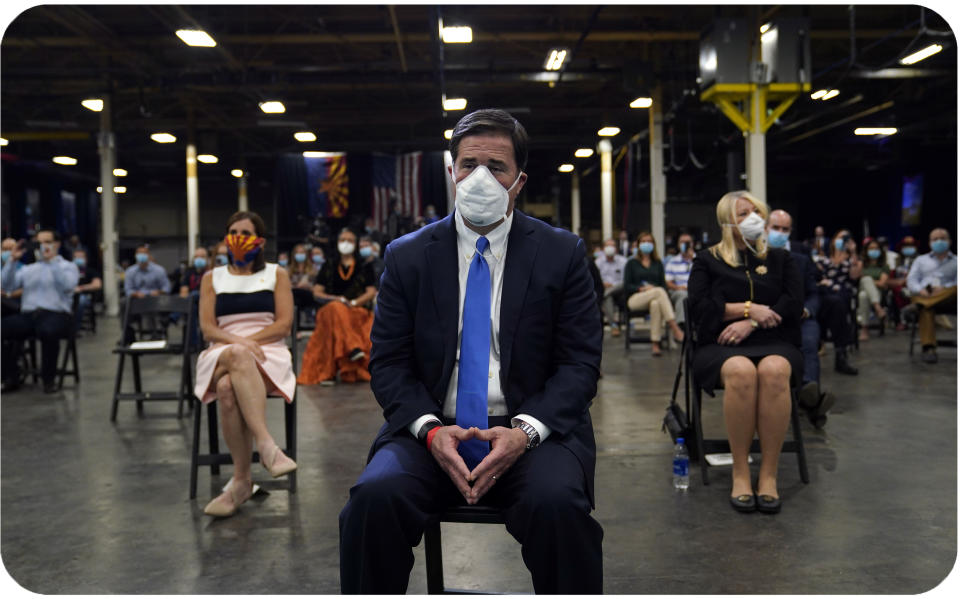 Arizona Gov. Doug Ducey waits to hear President Donald Trump speak at a Honeywell plant manufacturing personal protective equipment in Phoenix.