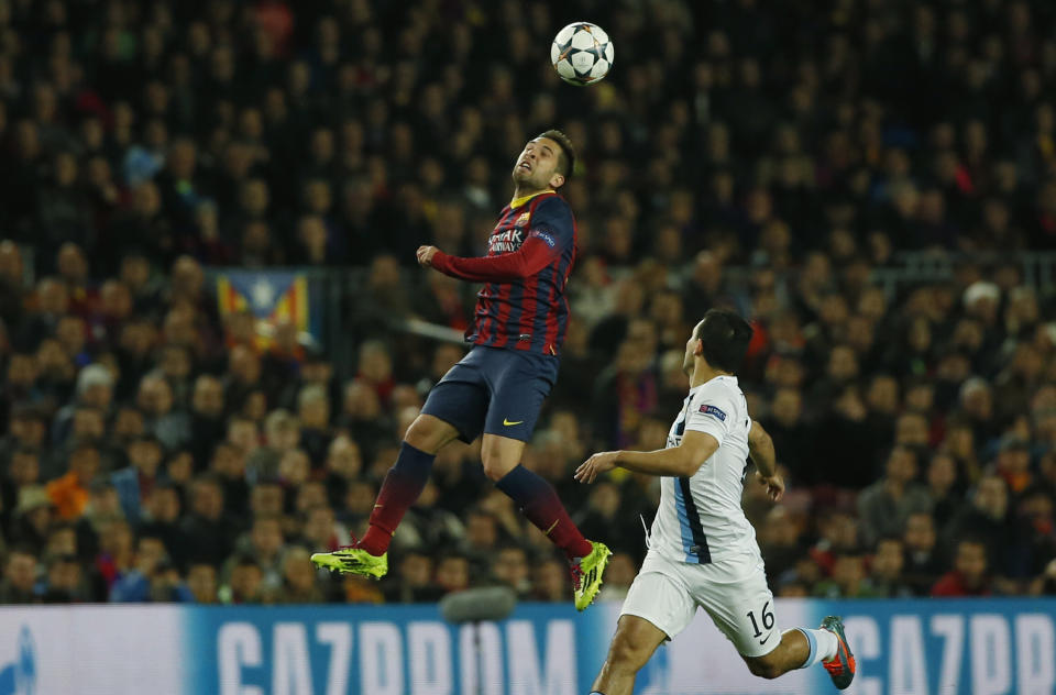 Barcelona's Jordi Alba, left jumps above Manchester City's Sergio Aguero during a Champions League, round of 16, second leg, soccer match between FC Barcelona and Manchester City at the Camp Nou Stadium in Barcelona, Spain, Wednesday March 12, 2014. (AP Photo/Emilio Morenatti)