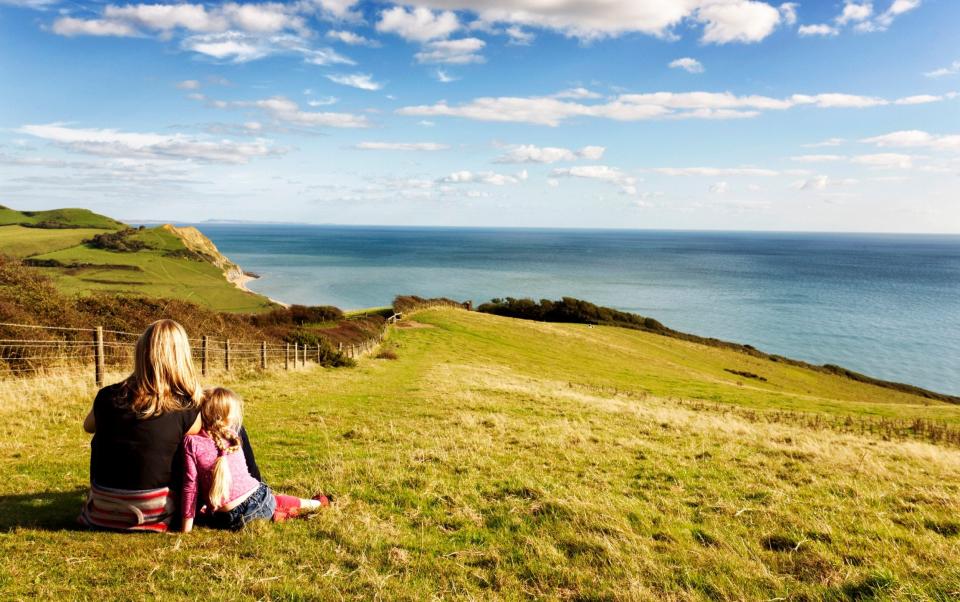 A mother and her daughter look at the Jurassic Coast, Dorset, UK