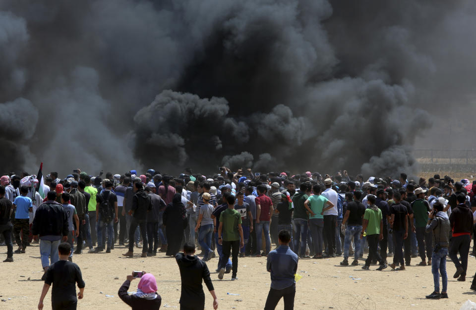 Palestinian protesters burn tires near the Israeli border fence in the Gaza Strip (Picture: AP)