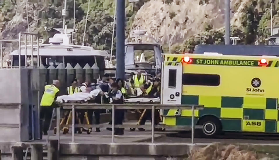 En esta imagen tomada de un video, personas lesionadas tras una erupción volcánica en la isla White son subidas a ambulancias en Whakatane, Nueva Zelanda, el lunes 9 de diciembre de 2019. (Katee Shanls/NZME vía AP)