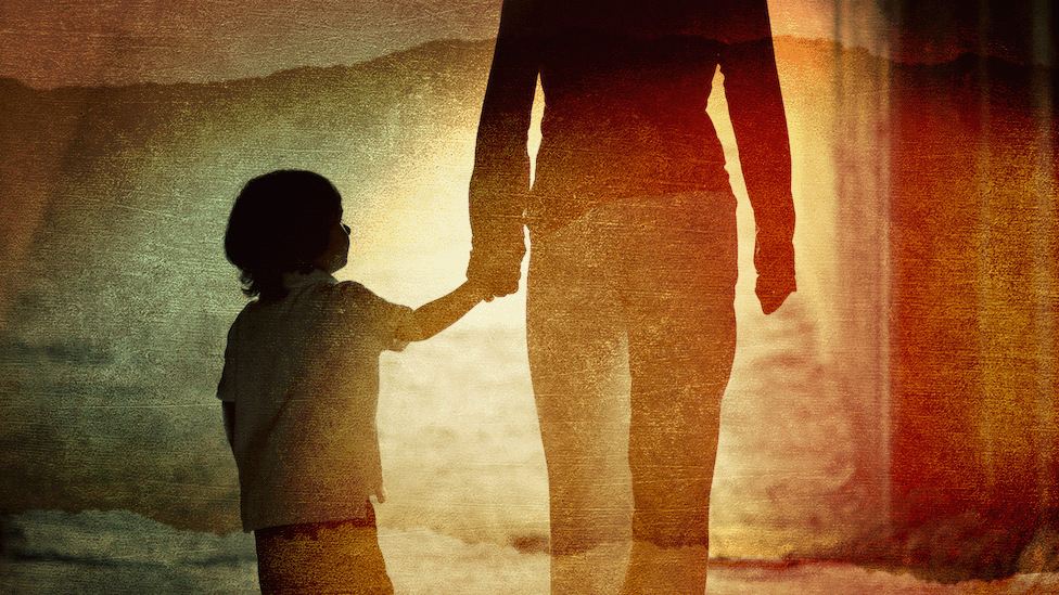 Child holding hands with adult