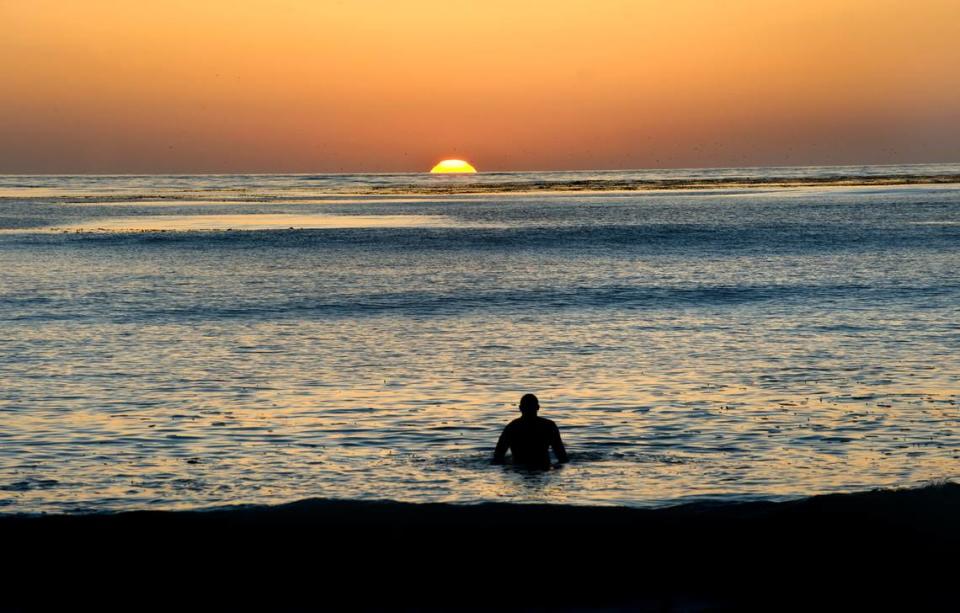 A surfer watches the sun set from the ocean in Carmel-by-the-Sea. September 2010.