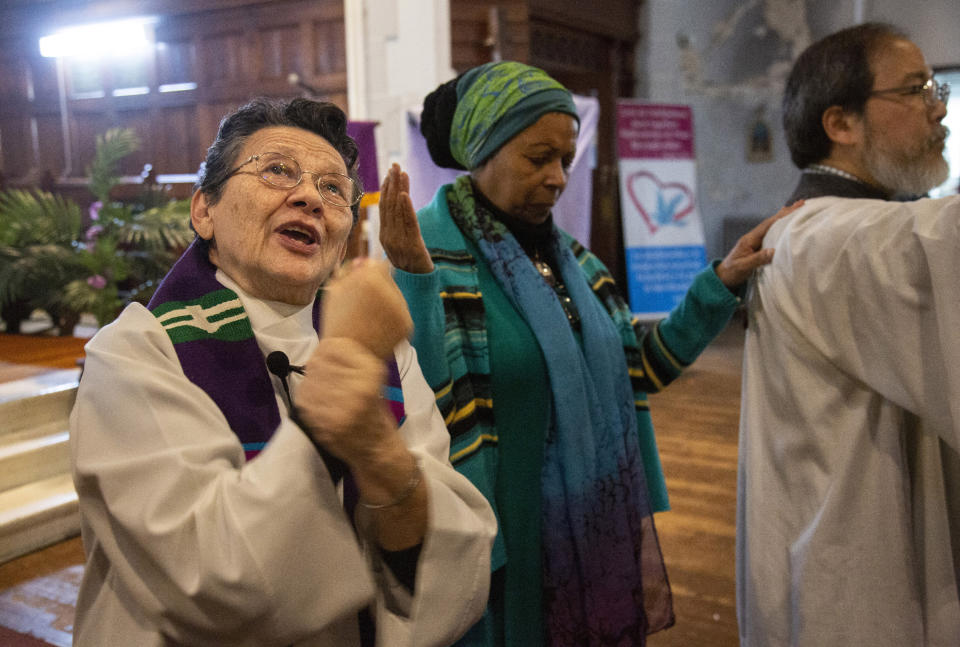 In this Sunday, Dec. 15, 2019, photo, the Rev. Maria Santiviago, left, signs the sermon for deaf worshippers at Holyrood Episcopal Church-Iglesia Santa Cruz in New York. Santiviago is a 77-year-old Paraguayan who came out of retirement to help lead the ministry for the deaf. (AP Photo/Jessie Wardarski)