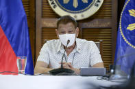 In this photo provided by the Malacanang Presidential Photographers Division, Philippine President Rodrigo Duterte wears a protective mask as he meets members of the Inter-Agency Task Force on the Emerging Infectious Diseases in Davao province, southern Philippines on Monday Sept. 21, 2020. Duterte says he has extended a state of calamity in the entire Philippines by a year to allow the government to draw emergency funds faster to fight the COVID-19 pandemic and harness the police and military to maintain law and order. (Albert Alcain/Malacanang Presidential Photographers Division via AP)