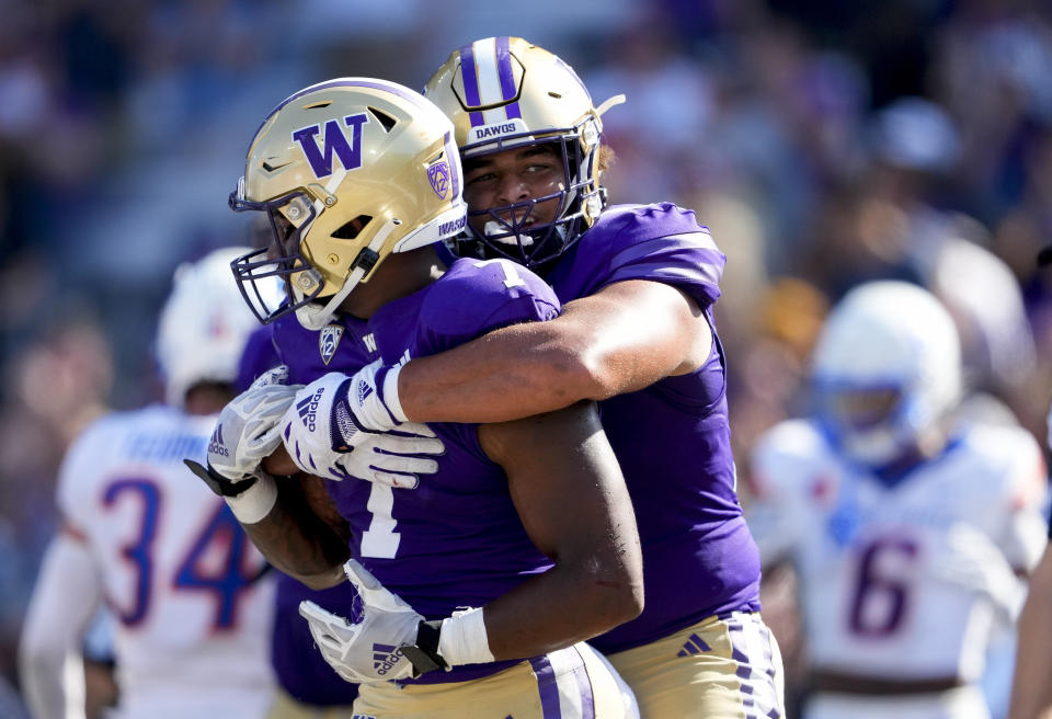 Washington running back Dillon Johnson is hugged by offensive lineman Parker Brailsford after rushing for a touchdown against Boise State during the second half of an NCAA college football game Saturday, Sept. 2, 2023, in Seattle. (AP Photo/Lindsey Wasson)