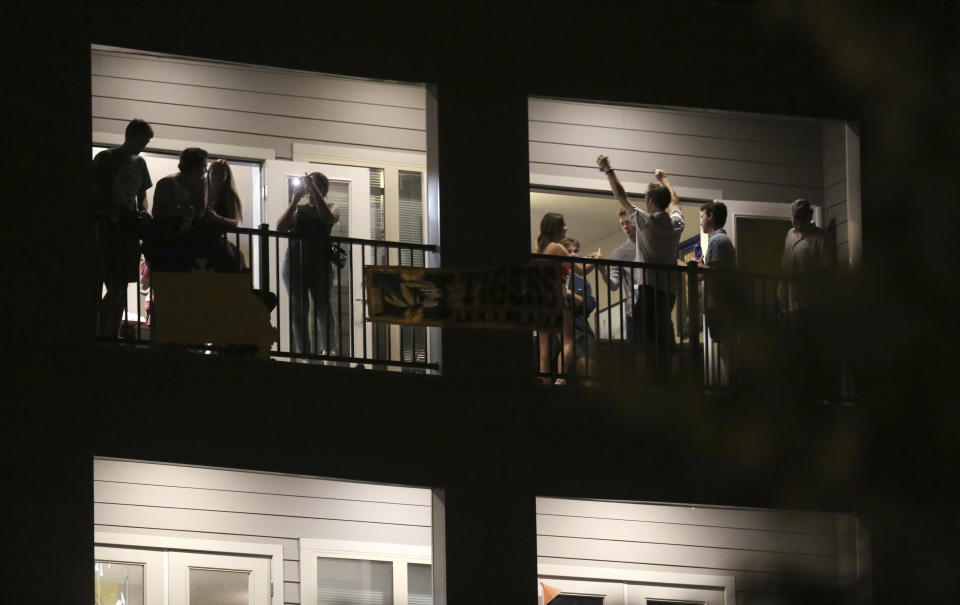 Partiers congregate on the balcony of a downtown apartment on Tuesday, Sept. 1, 2020, in Columbia, Mo., near the University of Missouri campus. Many colleges quickly scrapped in-person learning in favor of online after cases began to spike, bars have been shut down in college towns, and students, fraternities and sororities have been repeatedly disciplined for parties and large gatherings. (Dan Shular/Missourian via AP)