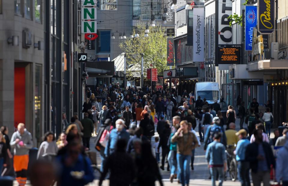 People walk past shops on a pedestrian street in Dortmund in Dortmund, western Germany, on April 20, 2020, during the novel coronavirus COVID-19 pandemic. - Some small shops in Germany reopened on Monday as the country took a cautious step toward returning to normal, though Chancellor Angela Merkel issued a stark warning against complacency in the face of the pandemic. (Photo by Ina FASSBENDER / AFP) (Photo by INA FASSBENDER/AFP via Getty Images)