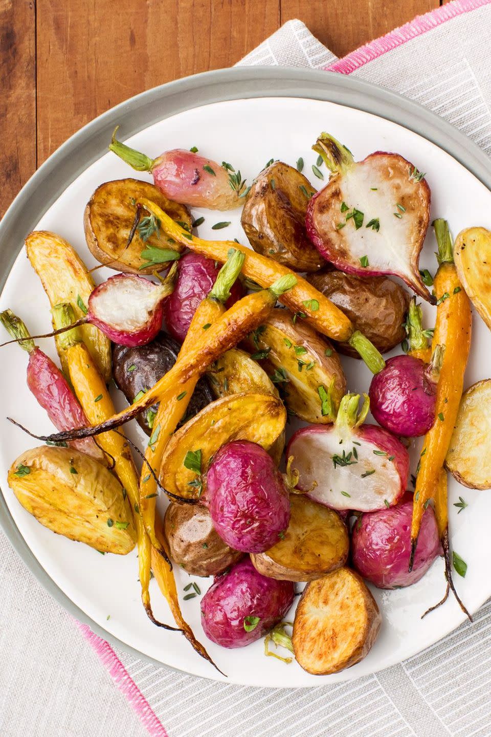 a close up of herb roasted root vegetables on a white plate