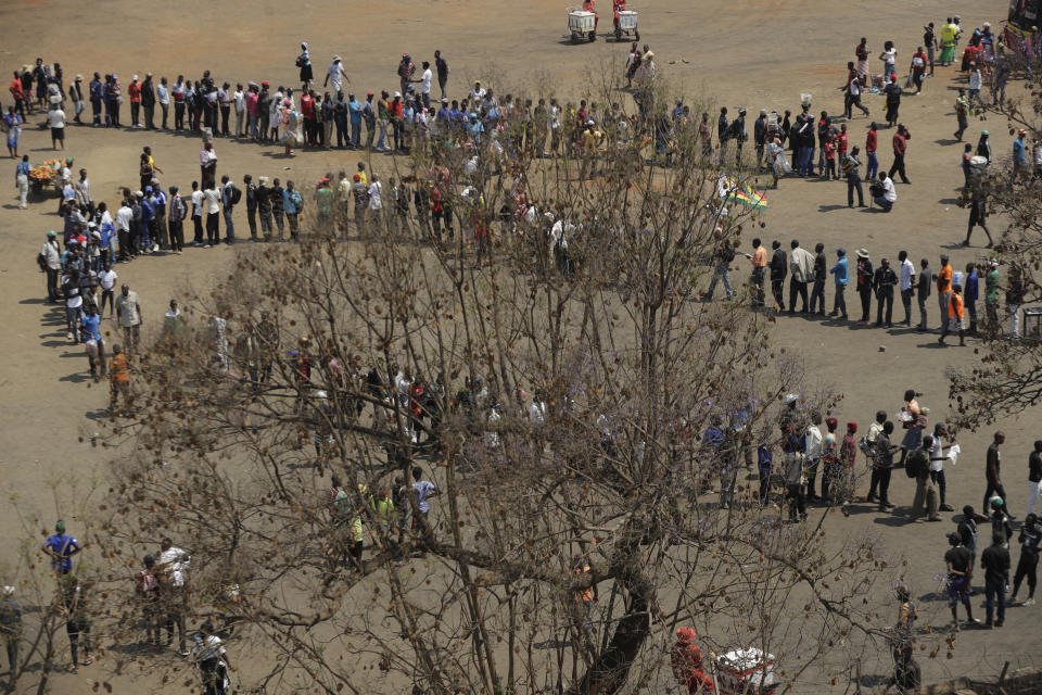 People queue at the Rufaro Stadium in Harare, Thursday, Sept. 12, 2019, where former President Robert Mugabe will lie in state for a public viewing. The body of the former guerrilla leader is to be on view at several historic sites in the next few days but where and when he will be buried has not been announced. (AP Photo/Themba Hadebe)