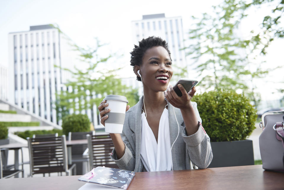 Portrait of smiling businesswoman on the phone at sidewalk cafe