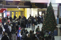 Passengers at Gatwick airport wait for their flights following the delays and cancellations brought on by drone sightings near the airfield, in London, Friday Dec. 21, 2018. New drone sightings Friday caused fresh chaos for holiday travelers at London's Gatwick Airport. (John Stillwell/PA via AP)