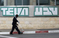 A man cleans near the logo of Teva Pharmaceutical Industries at their plant in Jerusalem December 14, 2017. REUTERS/Ammar Awad