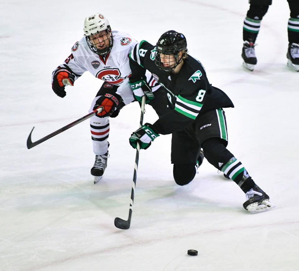 St. Cloud State's Easton Brodzinski and Jake Schmaltz of North Dakota battle for control of the puck during the first period of the game Saturday, Dec. 4, 2021, at the Herb Brooks National Hockey Center in St. Cloud.