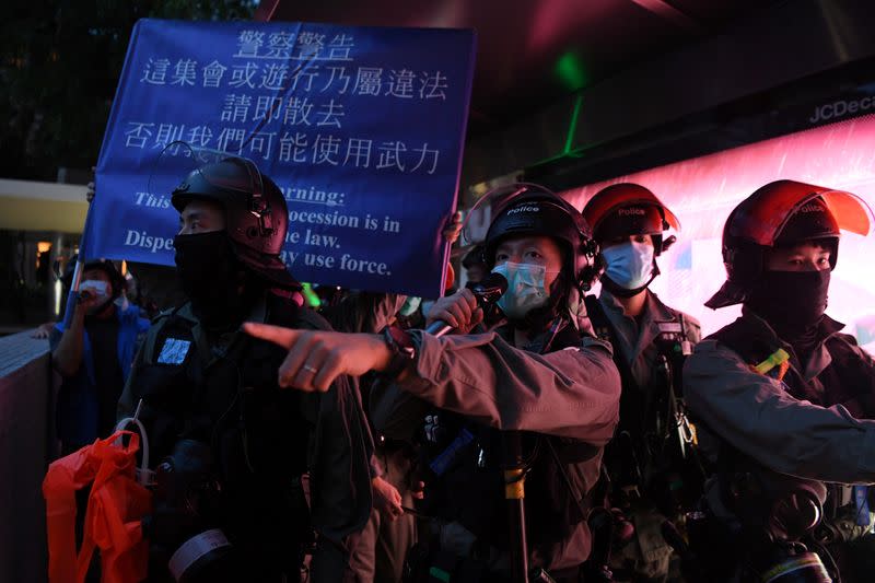 Police raise a banner warning demonstrators near the Court of Final Appeal during a protest on the first anniversary of a mass protest against the now-withdrawn extradition bill, in Hong Kong