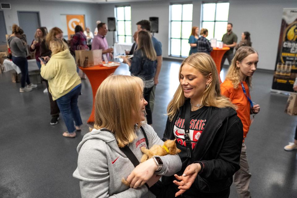 Ohio State hockey players Quinn Kuntz, right, plays with a kitten with teammate Emma Maltais during a fundraiser at Columbus Humane. Kuntz and Maltais are represented by Cohesion Foundation, a non-profit that represents OSU athletes for name, image, and likeness marketing purposes.