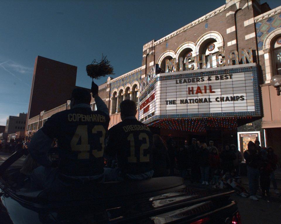 Clint Copenhaver and Scott Dreisbach ride in the back of a car waving to thousands of fans in front of the Michigan Theatre's marquee that said it all for the University of Michigan's storybook season during a parade in 1997.